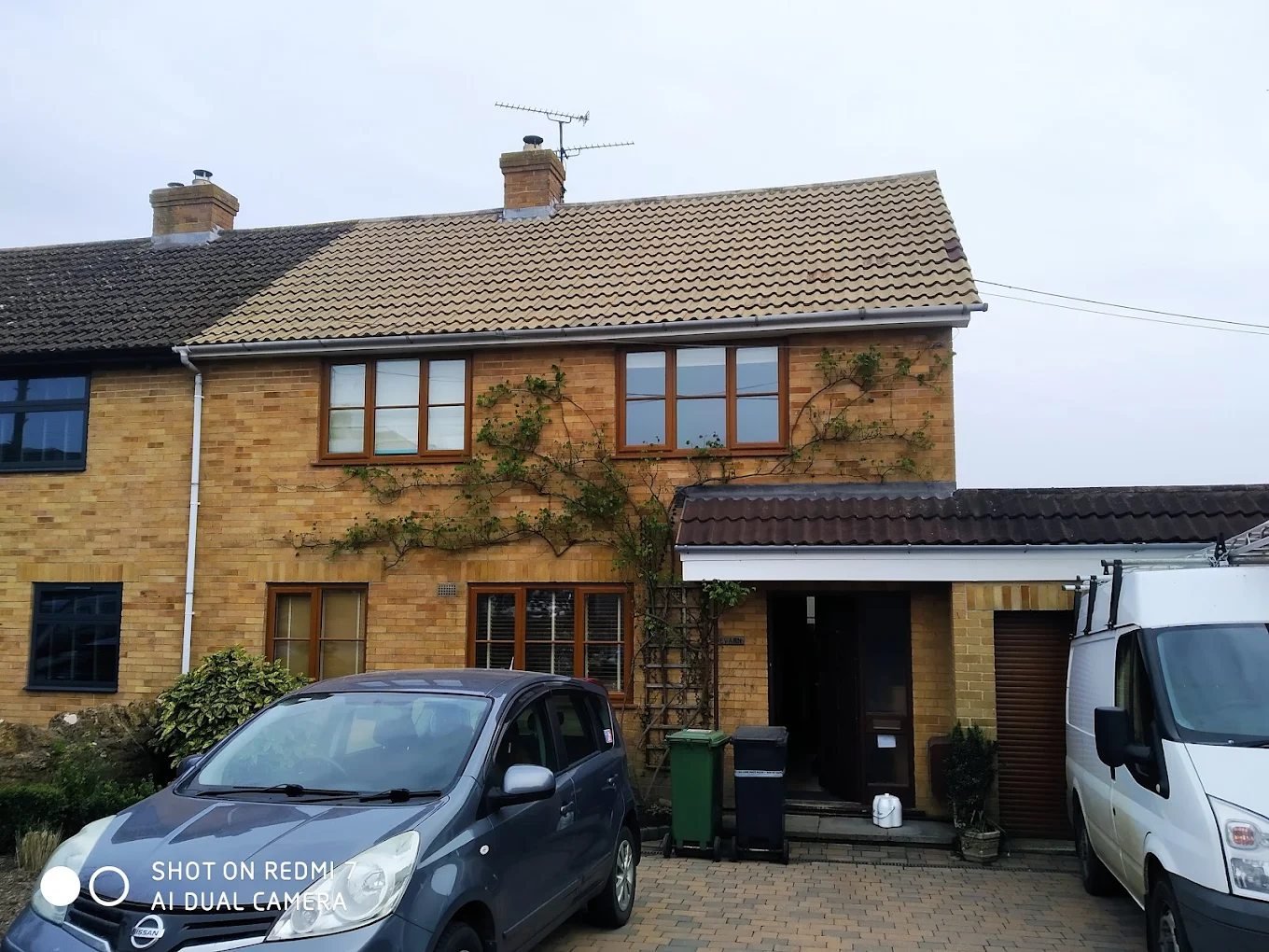 Brick house with its roof tiles cleaned back to their original colour